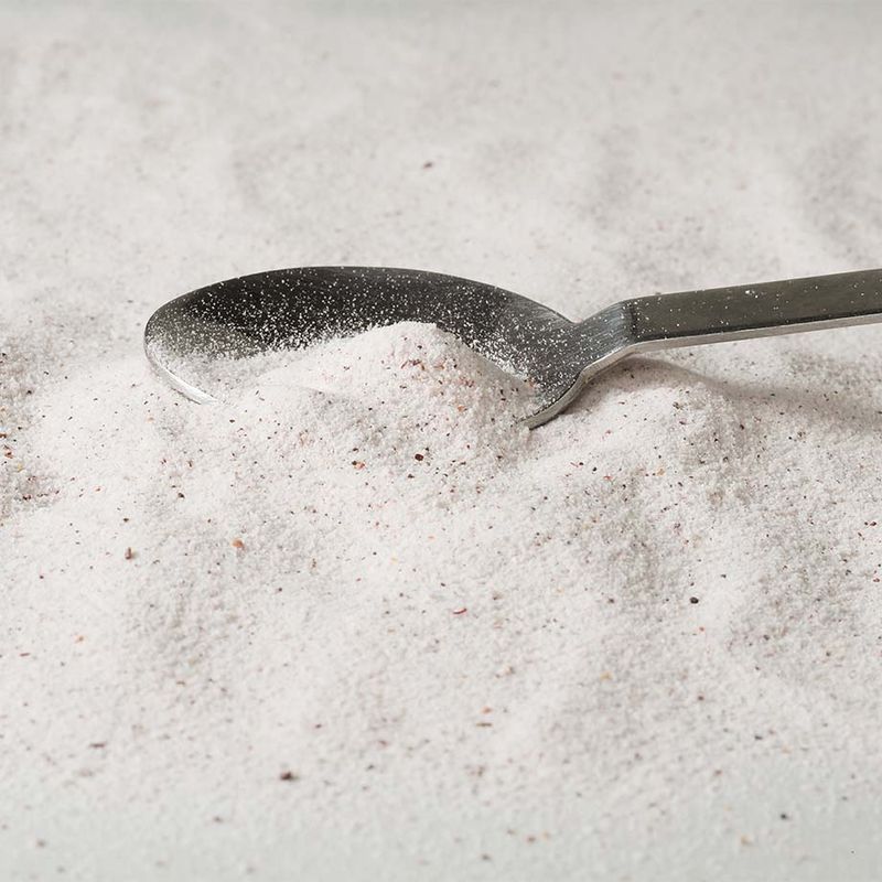 Colágeno em pó espalhado com uma colher metálica.