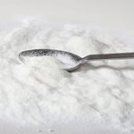 Colágeno em pó espalhado com uma colher metálica.