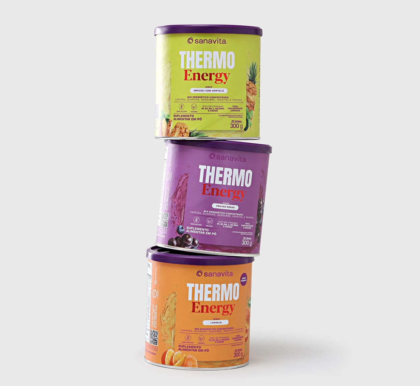 Três potes empilhados de Thermo Energy Sanavita, nos sabores abacaxi com hortelã, frutas vermelhas e laranja, sobre fundo neutro.