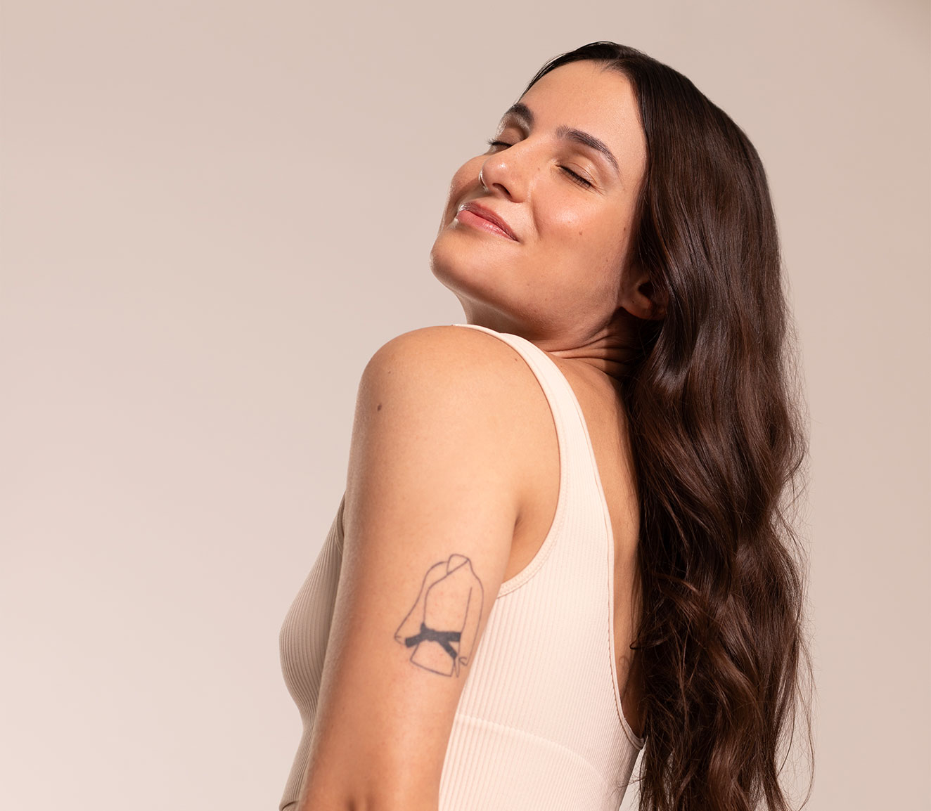 Mulher segurando um copo com bebida vermelha, olhando para cima com expressão tranquila.