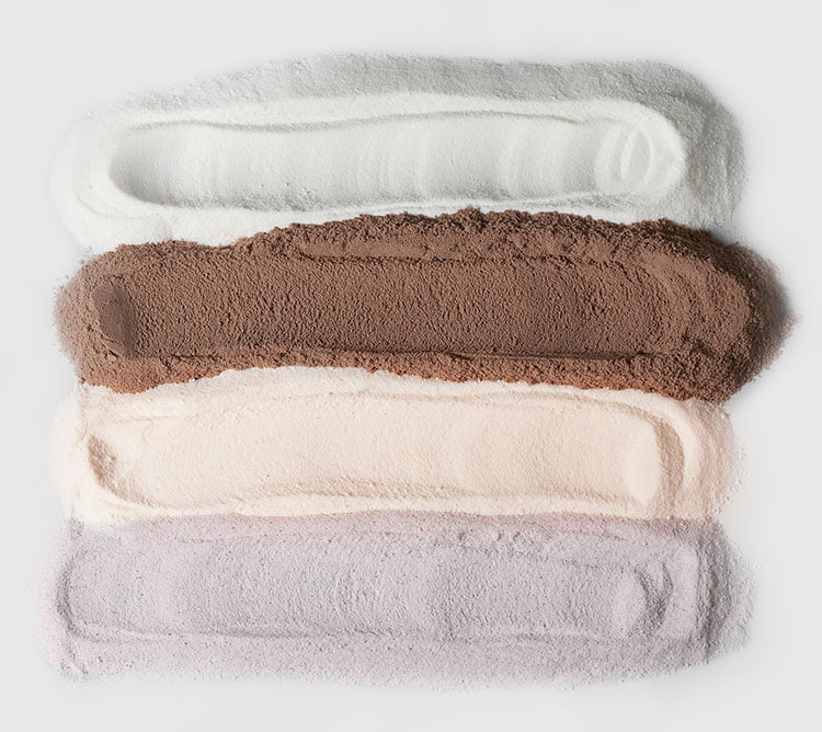 Cinco diferentes tipos de proteínas em pó da BodyBalance, dispostos em linhas horizontais com cores variando de branco a roxo.